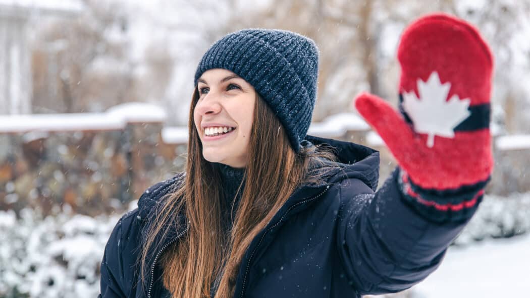 women wearing red mittens with Canadian flag in a snowy weather