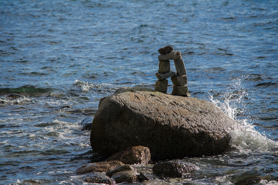 stacked pebbles on a rock surrounded by water